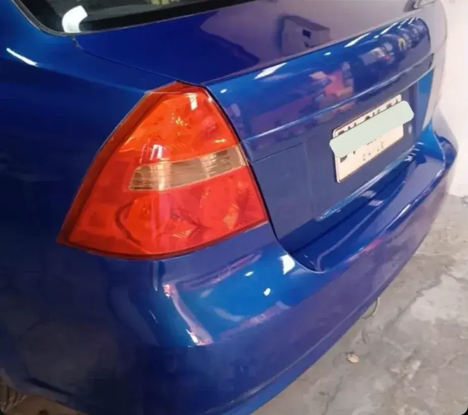Después: Chevrolet Aveo azul con la parte trasera repintada