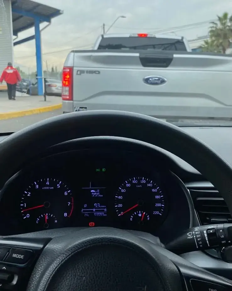 Vista desde un Kia durante una revisión técnica: delante, una Ford F-150 en la fila