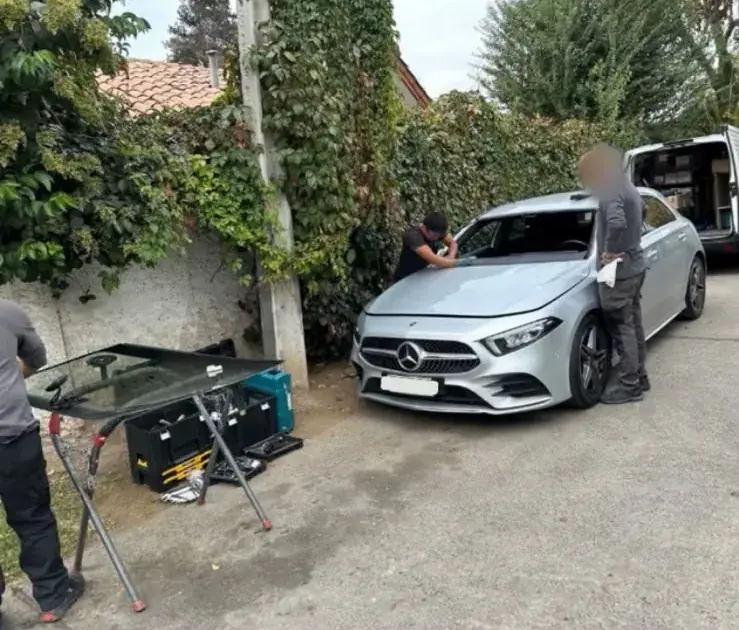 Cambio de parabrisas de un Mercedes-Benz: el vidrio nuevo sobre un soporte junto al auto